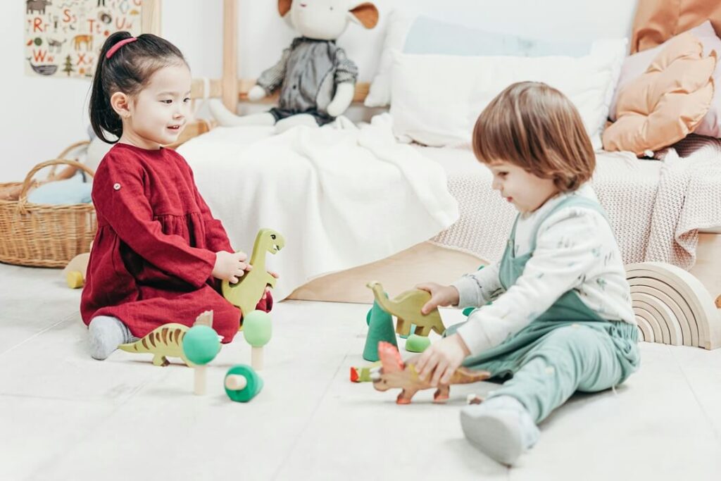 2 children playing on the floor with toys, organising kids rooms
