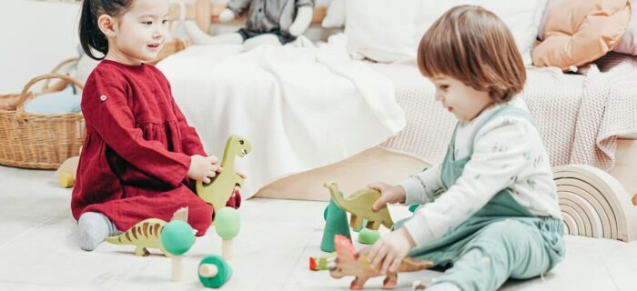 2 children playing on the floor with toys, organising kids rooms